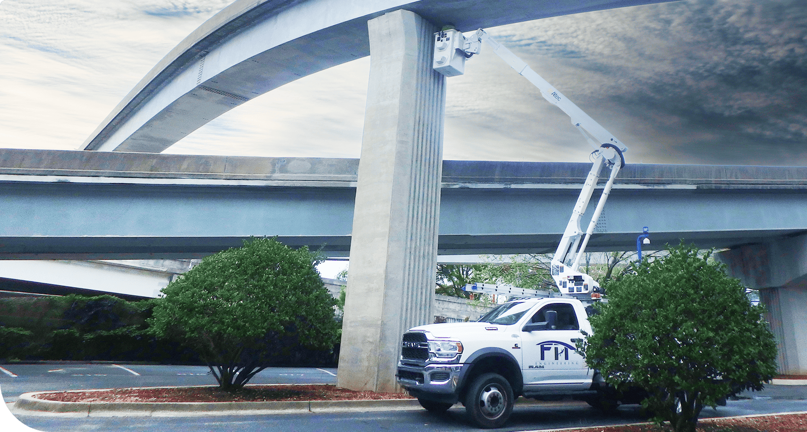 Elevated highway construction inspection using bucket truck for bridge maintenance.