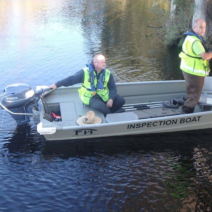 Monitoring water quality with an inspection boat on a calm river.